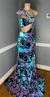 A medium-sized sequin dress featuring a mermaid train and bodice mesh cutouts, predominantly in blue, purple, and black colors by Bellz Couture in Detroit.