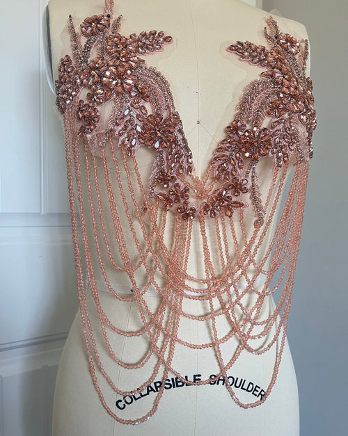 rose gold applique. Rose gold beaded and chain shoulder piece on a mannequin with 'Collapsible Shoulder' label. Bellz Couture Detroit 
