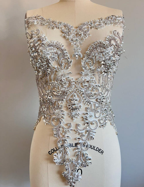 Silver beaded top on a mannequin with a plain background