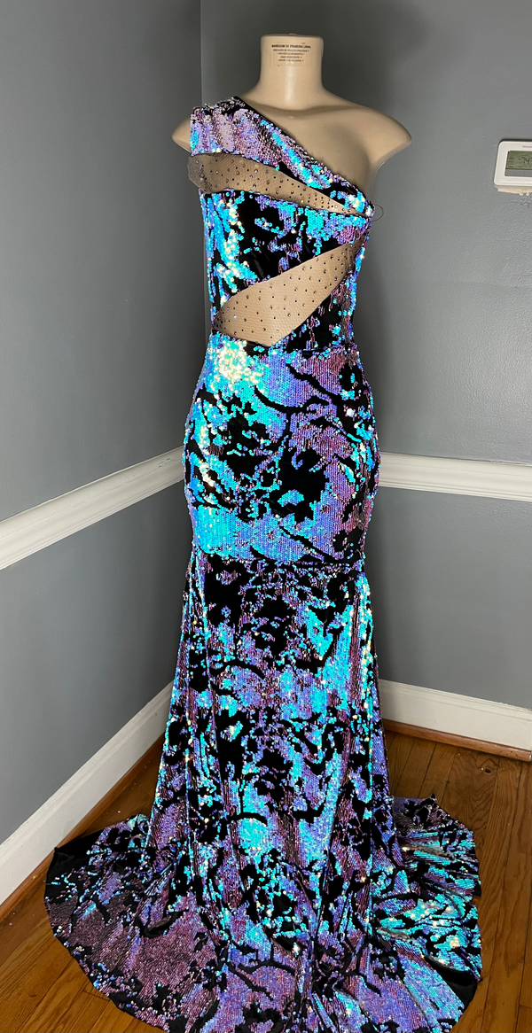 A medium-sized sequin dress featuring a mermaid train and bodice mesh cutouts, predominantly in blue, purple, and black colors by Bellz Couture in Detroit.