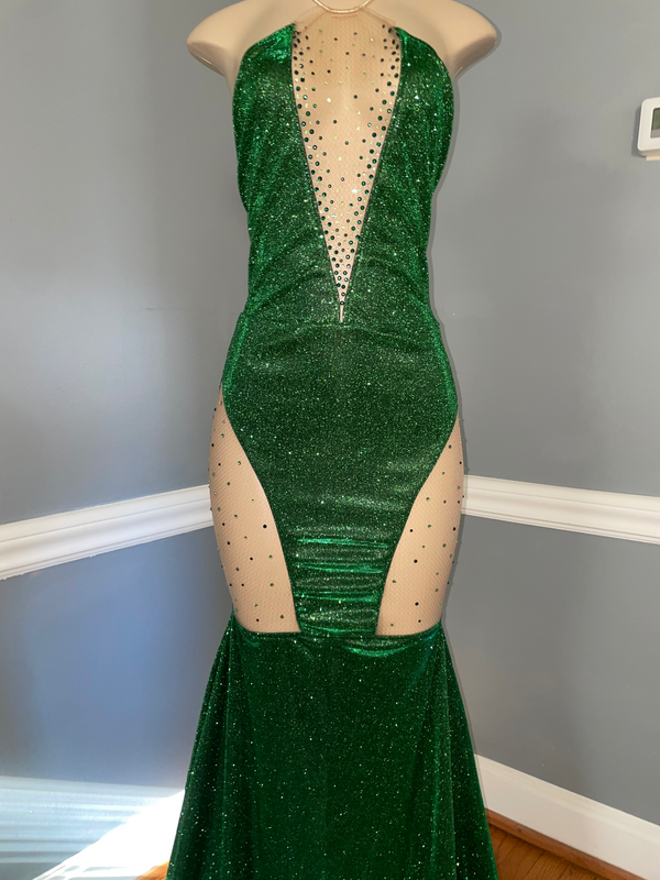 A green and gold glittery V-neck dress with thigh cutouts and a mermaid train, displayed on a mannequin by Bellz Couture in Detroit.